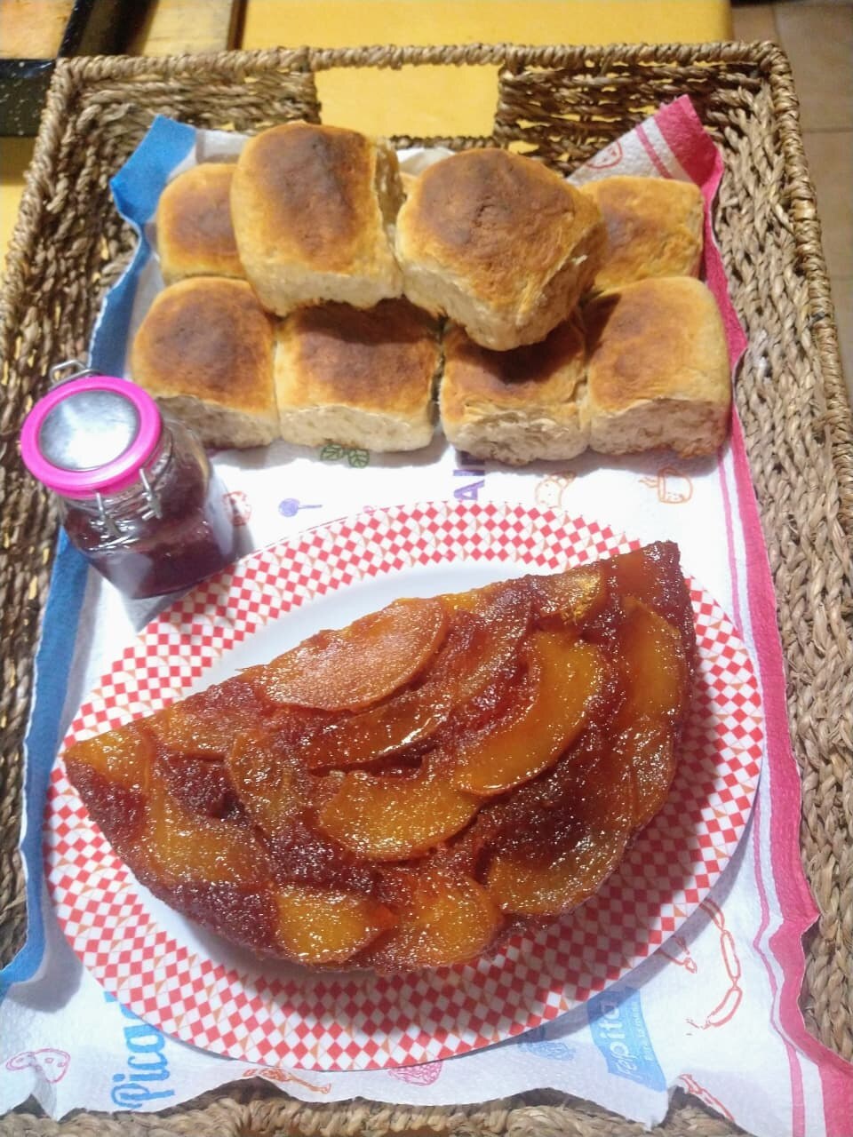 Canasta con pancitos caseros, torta de manzanas y un frasco de dulce