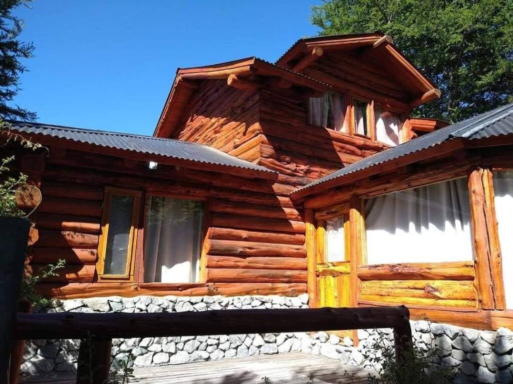 Cabaña de troncos de dos plantas con techo de chapa, al sol